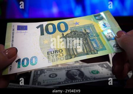 Shanghai, China. 31. August 2024. In dieser Abbildung hält eine Person eine Euro-Barrechnung mit US-Dollar im Hintergrund. Quelle: SOPA Images Limited/Alamy Live News Stockfoto