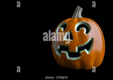 Eine Nahaufnahme eines geschnitzten halloween-Kürbis mit einem grinsenden Gesicht, isoliert auf schwarzem Hintergrund. Stockfoto