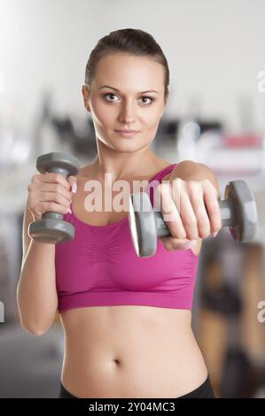 Frau mit Hanteln in einem Fitnessstudio trainieren Stockfoto