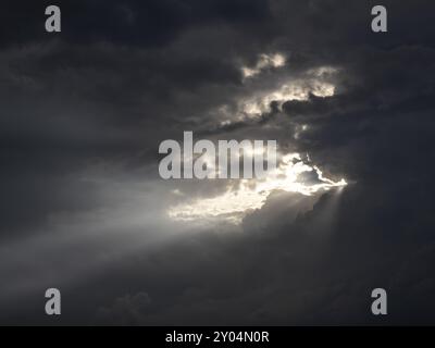 Sonnenstrahlen strahlen strahlen durch die dunkle Wolkendecke Stockfoto