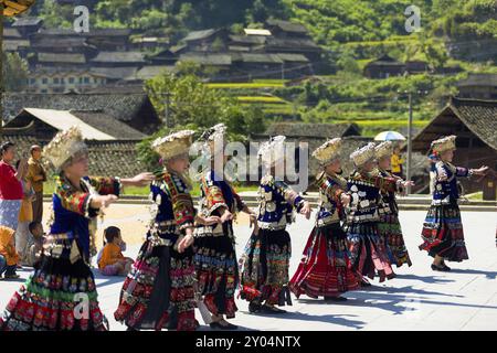 Xijiang, China, 15. September 2007: Miao-Frauen tanzen in vollen traditionellen Festivaljuwelen und farbenfrohen Kostümen mit silbernem Hornkopf in Xijiang Stockfoto