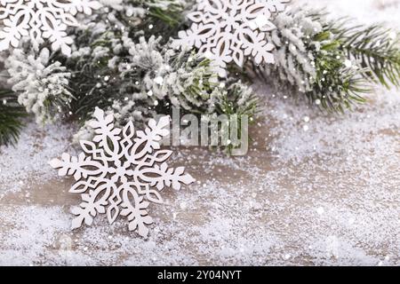 Nahaufnahme von weihnachtlicher hölzerner Schneeflocke Dekoration auf Schnee, Tannenbaum Kopierraum Stockfoto