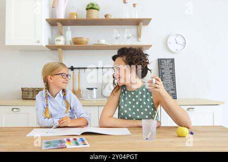 Mutter und Tochter Malerei zusammen zu Hause in der Küche mit Pinsel und Wasserfarben Stockfoto