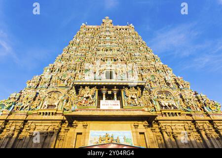 Das zentrale Tor zum Meenakshi Amman Tempel, bedeckt mit farbenfrohen Statuen von Göttern an einem Tag mit blauem Himmel in Madurai im südindischen Bundesstaat Tamil Stockfoto