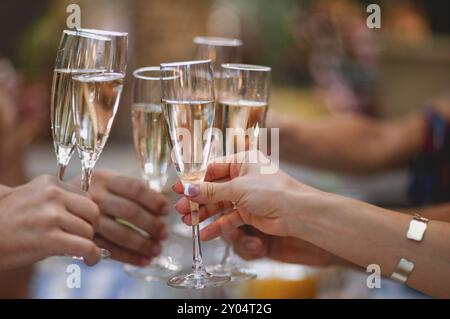 Feier. Leute, die Gläser Champagner zum Toasten halten. Fase mit verschwommenem Hintergrund Stockfoto