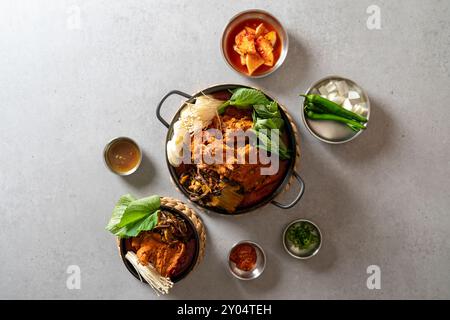 Koreanisches Essen, Gamjatang, Knochenkater-Suppe, Erdtopf, Schweinefleisch-Rückgrat, perilla-Blätter, Beilagen, Stockfoto