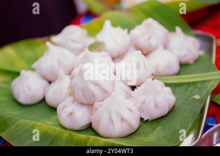 Maharashtrian süß von Modak, das Lord Ganesh angeboten wird, garniert mit Safran (Kesar), das man mit Ghee Schüssel und Lord Ganpati im Hintergrunde essen kann Stockfoto