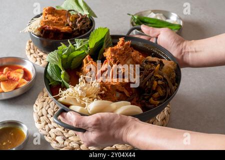 Koreanisches Essen, Gamjatang, Knochenkater-Suppe, Erdtopf, Schweinefleisch-Rückgrat, perilla-Blätter, Beilagen, Stockfoto