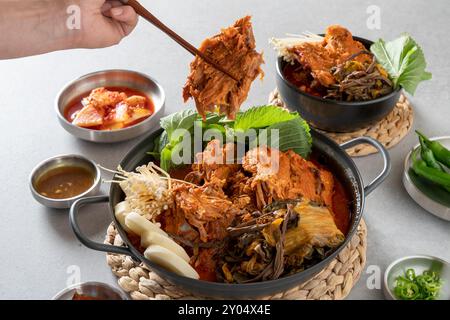 Koreanisches Essen, Gamjatang, Knochenkater-Suppe, Erdtopf, Schweinefleisch-Rückgrat, perilla-Blätter, Beilagen, Stockfoto