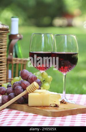 Verschiedene Arten von Käse, Weintrauben und zwei Gläser Rotwein Stockfoto