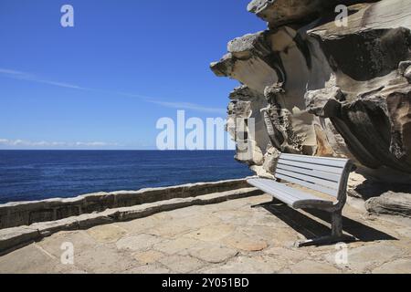 Naturhintergrund. Szene in der Nähe von Bondi Beach, Sydney. Azurblauer Pazifik, Bank und wunderschön geformter Felsen Stockfoto