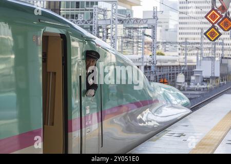 Tokio, Japan, 23. Dezember 2014: Ein Shinkansen-Zugbetreiber schaut vor der Abfahrt aus dem Fenster, Asien Stockfoto