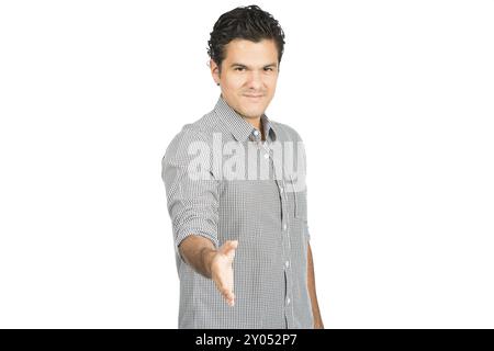 Freundlicher, gut aussehender hispanischer Mann in lässigem Hemd, der sich ausdehnt und Handschlag anbietet, direkt in die Kamera blickt, warm mit einem fürsorglichen smil begrüßt Stockfoto