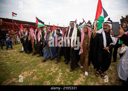 Gaza, Palästina. 18. März 2023. Die Palästinenser beginnen in der Stadt Deir El Balah im zentralen Gazastreifen mit palästinensischen Nationalflaggen. Einige der Teilnehmer trugen traditionelle palästinensische Kostüme und brachten Banner auf, die ihre Entschlossenheit zum Ausdruck brachten, in das Land ihrer Vorfahren im heutigen Israel zurückzukehren. Der Landtag fällt am 30. März und würdigt die sechs getöteten Palästinenser und die Hunderte Verletzten der israelischen Polizei, während sie gegen die Enteignung palästinensischen Landes durch die israelische Regierung in Galiläa im Naqab protestieren Stockfoto