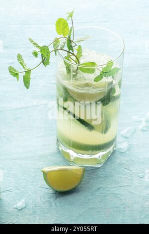 Mojito-Cocktail. Kaltes Sommergetränk mit Limette, frischer Minze und Eis. Kühles Getränk auf blauem Hintergrund Stockfoto