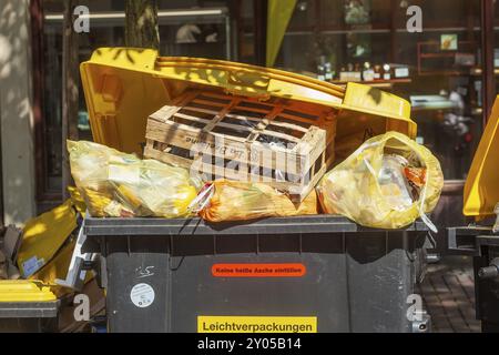 Überfüllte Abfallbehälter für leichte Verpackungen stehen auf der Straße, Deutschland, Europa Stockfoto