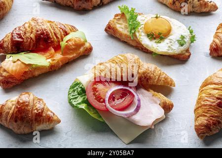 Croissant-Sandwichsortiment. Verschiedene gefüllte Croissants. Mit Schinken, Lachs, Ei usw. gefüllte Brötchen Stockfoto