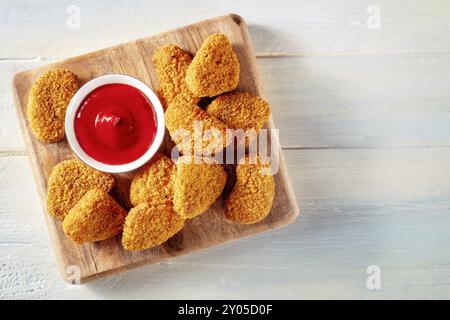 Chicken Nuggets mit Ketchup Sauce auf einem rustikalen Holztisch, von oben mit einem Platz für Text geschossen Stockfoto