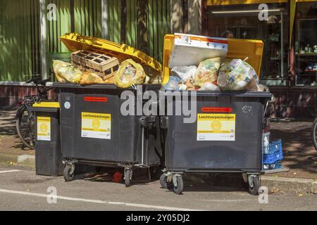 Überfüllte Abfallbehälter für leichte Verpackungen stehen auf der Straße, Deutschland, Europa Stockfoto