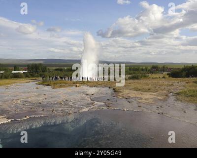 Blesi Thermalquelle in Haukadalur, im Hintergrund der Strokkur Geysir in Island Stockfoto