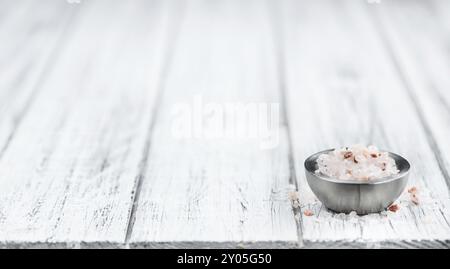 Salz (rosa) auf einem alten Holztisch als detaillierte Nahaufnahme (Tiefenschärfe) Stockfoto