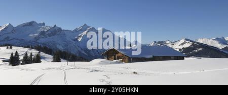 Alte Holzhütte und schneebedeckte Berge Schlauchhorn, Oldenhorn und Vorder Walig Stockfoto