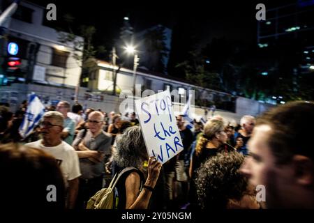 Tel Aviv, Israel. 31. August 2024. Ein Demonstrant hält ein Schild mit der Aufforderung, den Krieg während eines Protestes am Samstag, 31 2024. August in Tel Aviv zu stoppen. Israel sagt, dass seine Truppen die Leichen von sechs Geiseln, die von der Hamas im Gazastreifen festgehalten wurden, geborgen haben. In einer Erklärung sagten die israelischen Verteidigungskräfte (IDF), dass die Leichen am Samstag in einem unterirdischen Tunnel im Gebiet Rafah im südlichen Gazastreifen gefunden wurden. Die IDF nannte die Geiseln Carmel Gat, Eden Yerushalmi, Hersh Goldberg-Polin, Alexander Lobanov, Almog Sarusi und Meister Sgt Ori Danino. Foto von Eyal Warshavsky. Quelle: Eyal Warshavsky/Alamy Live News Stockfoto