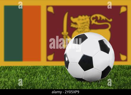 Die Flagge Sri Lankas und der Fußball auf dem grünen Gras Stockfoto