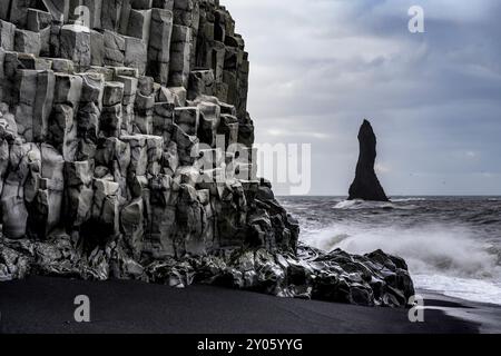 Reynisdrangar - Basaltmeerstapel - und Basaltsäulen am Raynisfjara (schwarzer Sandstrand) in Vik, Süd-Island. Stockfoto