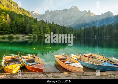 Malerischer Laghi di Fusine See mit farbenfrohen Booten Stockfoto