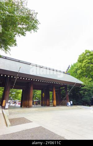 Tokio, Japan, 30. Juli 2015: Menschen gehen durch die hölzerne Shinmon-Tür am Eingang des umstrittenen Yasukuni-Shinto-Schreins an einem trüben bedeckten Tag. Stockfoto