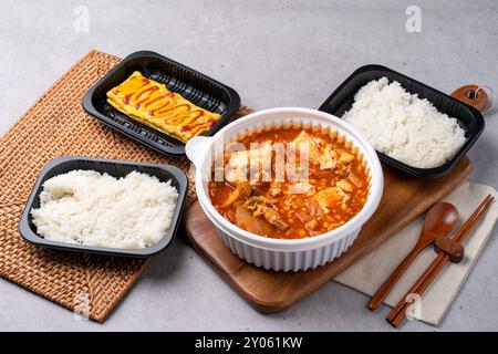 Koreanisches Essen, Kimchi-Eintopf, Schinken, weicher Tofu, Schweinefleisch, Eierbrötchen, Reis, Beilagen Stockfoto