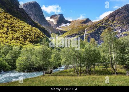 Wasserfall, Fluss und grüne Bäume auf dem Weg zum Briksdal oder Briksdalsbreen Gletscher in Olden, Norwegen, Europa Stockfoto