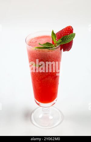 Erdbeersaft in einem klaren Glas mit Erdbeergarnitur trinken. Isoliert auf weißem Hintergrund Stockfoto