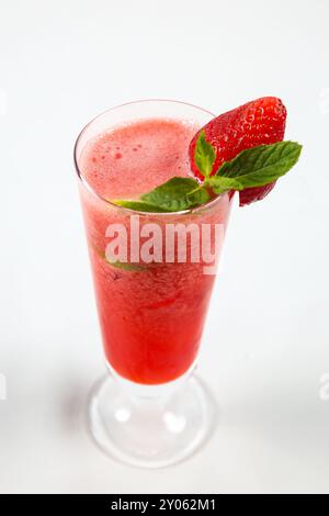 Erdbeersaft in einem klaren Glas mit Erdbeergarnitur trinken. Isoliert auf weißem Hintergrund Stockfoto