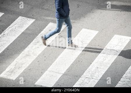 Hohe Betrachtungswinkel und der junge Mann am Zebrastreifen. Das Leben in der Stadt Stockfoto