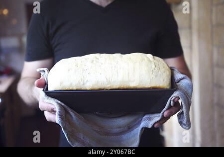 Männliche Hände Form mit frischem Teig auf die Küche. Nahaufnahme Stockfoto