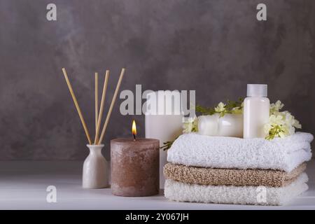 Spa-Massage und Wellness-Einstellung aromatische Sticks braune und weiße Handtücher Öl Seife Creme Salz Stockfoto