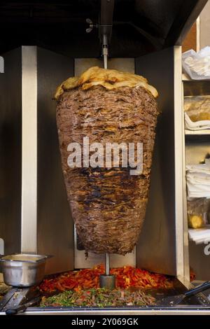 Ein großes Stück Schawerma-Lammfleisch kocht in einer Maschine, die man oft in Restaurants des Nahen Ostens findet Stockfoto