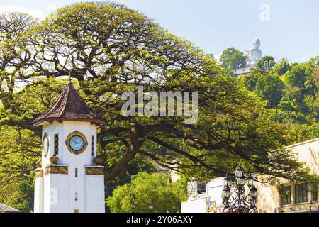 Ferne Bahiravokanda Vihara Buddha Statue gesehen über der Innenstadt von Kandy Glockenturm, ein Wahrzeichen der Stadt in Sri Lanka Stockfoto