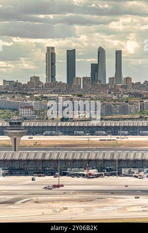 Madrid, Spanien; 18.05.2024: Flugzeuge, die vor dem Flughafenterminal Adolfo Suarez Madrid Barajas mit dem berühmten Büro der Stadt fünf einsteigen können Stockfoto