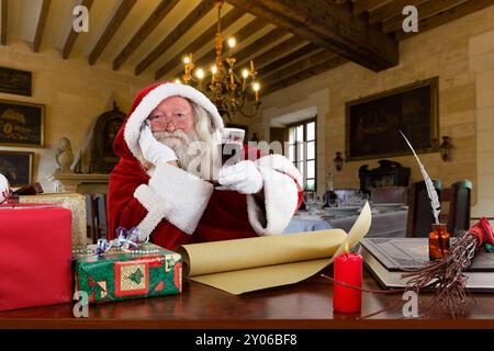 Vater Weihnachten mit einem Glas Rotwein in der Hand Stockfoto