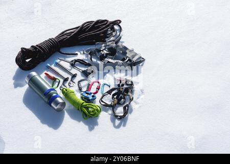 Nahaufnahme der Winterkletterausrüstung auf Neuschnee an einem sonnigen Tag. Karabiner mit Seilgazebo und Zhumar sowie andere Anpassungen beim Üben Stockfoto