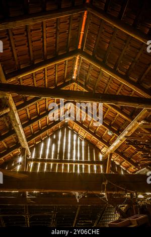 Innenraum eines alten Holzschuppen mit Holzabfällen und Sonnenstrahlen. Alte Scheune Stockfoto