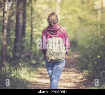 Junge Frau geht im Frühling durch den Wald Stockfoto