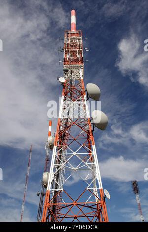 Rot-weiße Spitze der Bergkommunikationstürme und Satellitenantennen Stockfoto