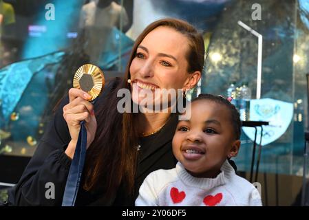 Johannesburg, Gauteng, Südafrika. 31. August 2024. Die Olympiasiegerin TATJANA SMITH zeigt die dreijährige ASANTE KETEYI ihre Medaille bei einem Welcome Home Event, das ihr Sponsor Under Armour in ihrem Flagship Store in Sandton City, Johannesburg, ausgetragen hat. (Kreditbild: © Neil McCartney/ZUMA Press Wire) NUR REDAKTIONELLE VERWENDUNG! Nicht für kommerzielle ZWECKE! Stockfoto