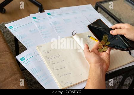 Finanzielle Probleme. Kaukasier mit vielen Rechnungen und ohne Geld. Knappheit, Konkurs, Steuern, kaum Geld in seiner Brieftasche. Stockfoto