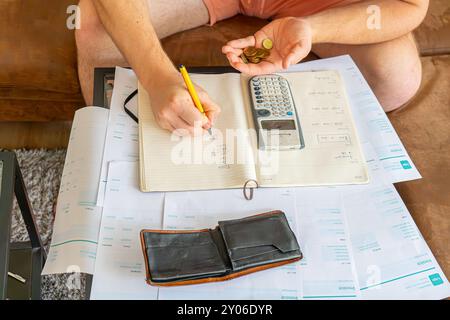 Finanzielle Probleme. Kaukasier mit vielen Rechnungen und ohne Geld. Knappheit, Konkurs, Steuern, kaum Geld in seiner Brieftasche. Stockfoto