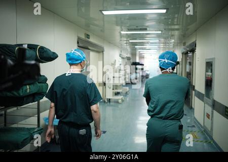 (240901) -- WUHU, 1. September 2024 (Xinhua) -- der nigerianische Student Ifeanyi Christian Onyebuchi (R) und sein Vorgesetzter Zhu Shaojin gehen zum Operationssaal des ersten angeschlossenen Krankenhauses der Wannan Medical College in Wuhu, ostchinesische Provinz Anhui, 30. August 2024. Ifeanyi Christian Onyebuchi ist ein nigerianischer internationaler Student, der seit 8 Jahren in China Medizin studiert. Ab 2022 begann Christian für seinen Master-Abschluss zu studieren, der von Zhu Shaojin, dem Direktor der Thoraxchirurgie-Abteilung des ersten angeschlossenen Krankenhauses der Wannan Medical College, betreut wurde. Neben dem Studium der theorie Stockfoto